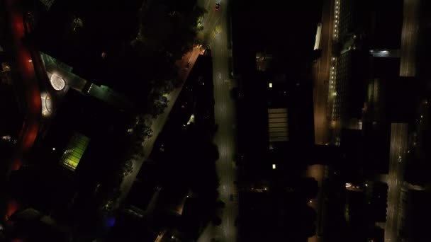 Ylhäällä panoroi laukaus kaduilla ja rakennuksissa kaupunkialueilla yöllä. Ajoneuvot ohittavat hitaasti tien risteyksen. Zürich, Sveitsi. - Materiaali, video