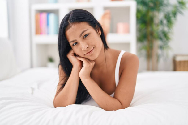 jong mooi latin vrouw dragen lingerie liggend op bed in slaapkamer - Foto, afbeelding