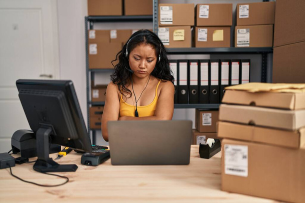 Young asian woman working at small business ecommerce wearing headset skeptic and nervous, disapproving expression on face with crossed arms. negative person.  - Foto, imagen