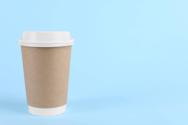 Paper cup with plastic lid on light blue background, space for text. Coffee to go - 写真・画像
