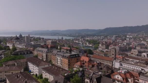 Форварды летают над зданиями в городском районе. Вид с воздуха на город и озеро. Цюрих, Швейцария. - Кадры, видео