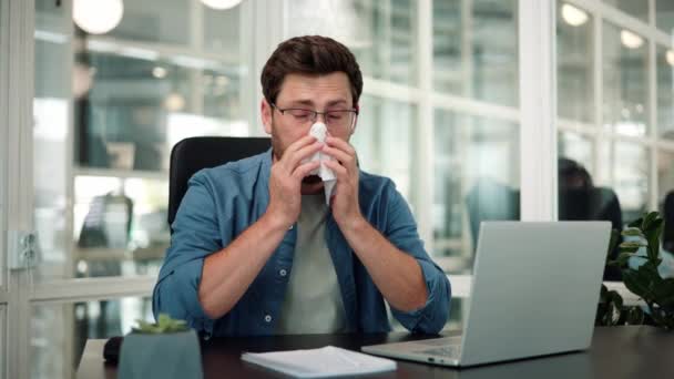 Нездоровый работник-мужчина чихает во время работы в офисе - Кадры, видео