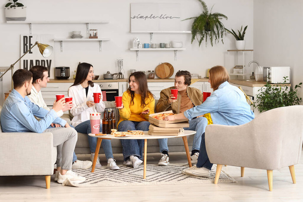 Grupo de amigos com pizza saborosa e bebidas em casa - Foto, Imagem