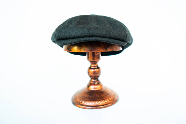 Fotografie klasického katalogu klobouku s osmipalcovou čepicí v útulné vlněné půlnoční černi, namontovaná na bronzové figuríně hlavy na bílém pozadí studia - Fotografie, Obrázek