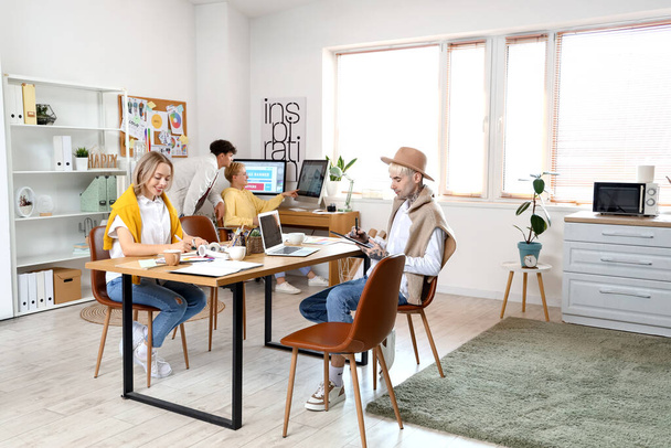 Equipo de diseñadores gráficos trabajando en la mesa en la oficina - Foto, imagen