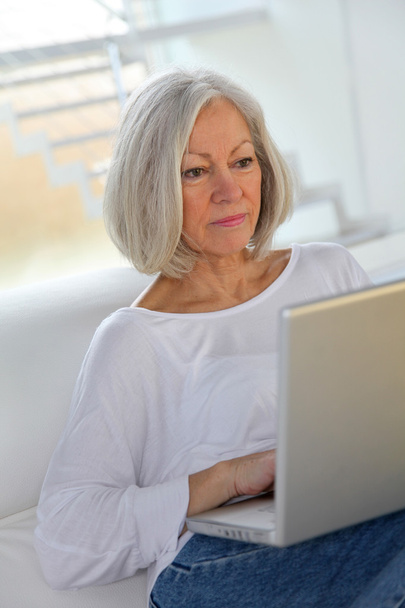 Senior woman surfing on internet at home - Foto, Imagem