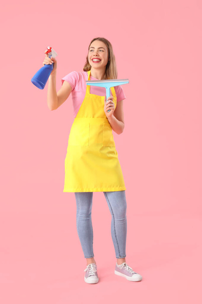 Nuori nainen pullo pesuainetta ja purista vaaleanpunainen tausta - Valokuva, kuva