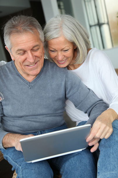 Happy senior couple connected on internet at home - Fotó, kép