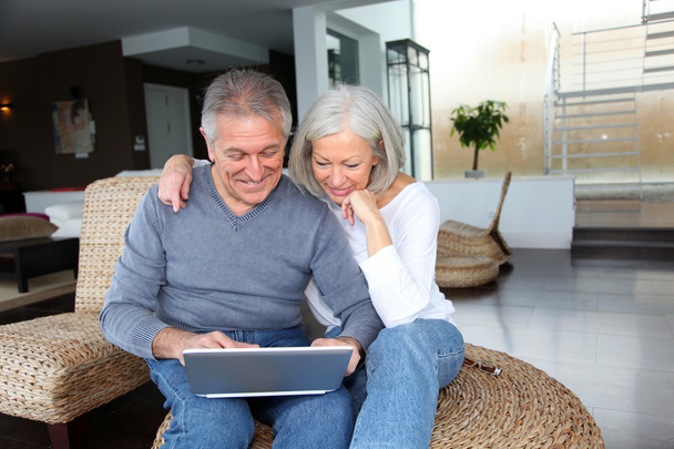 Happy senior couple connected on internet at home - Foto, Imagen