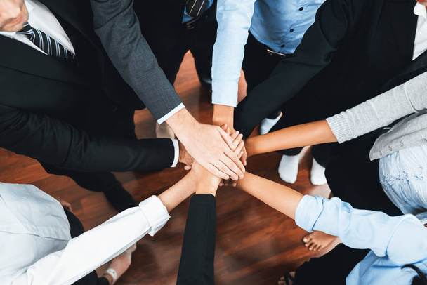 Multiracial business people make synergy hand stack together in meeting room as cooperation or team building for corporate employee in workplace. Meticulous - Photo, Image