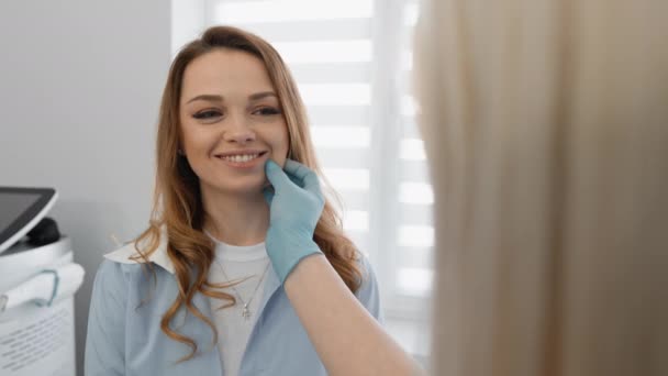 スキンケア: 開いた心を持つ女性は,クリニックで美容師とコミュニケーションをとり,スキンケアに関する推奨事項を聞きます. 完璧へのステップ:美容師のレセプションでの患者 - 映像、動画
