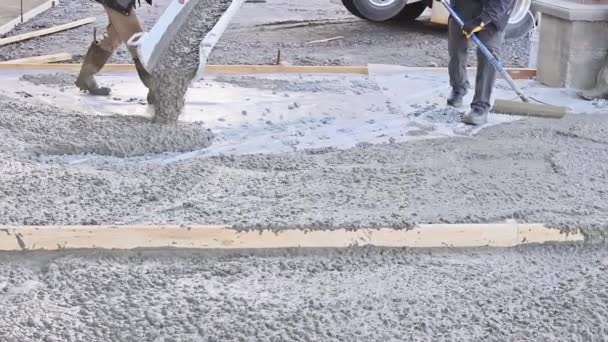 Рабочие на строительной площадке с обвальным бетоном готовые к выравниванию бетон для подъездной дорожки - Кадры, видео
