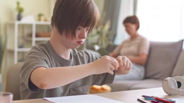 Ragazza di 14 anni con sindrome di Down che affila le matite mentre studia a casa - Filmati, video