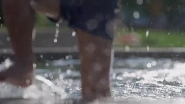 Dziecięce stopy wychodzące z basenu z kroplami wody spadającymi w zwolnionym tempie - Materiał filmowy, wideo