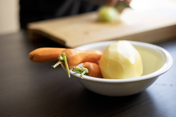 rohe Kartoffeln und Karotten zum Kochen in einer weißen Schüssel - Foto, Bild