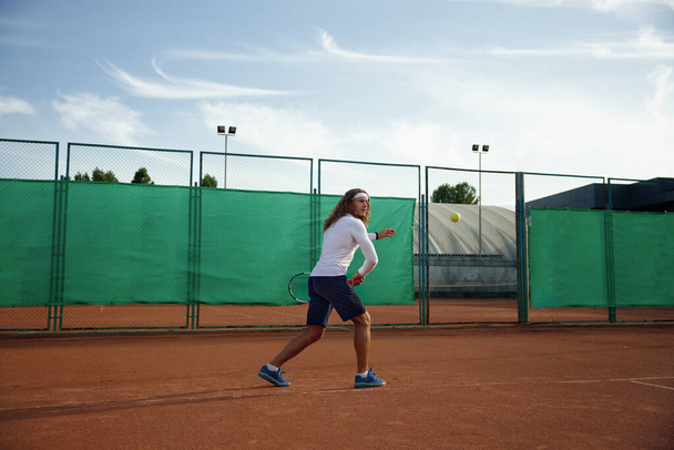 Mujer deportiva joven y hombre jugando partido de tenis en la cancha al aire libre durante el día soleado. Concepto de clase de formación - Foto, Imagen
