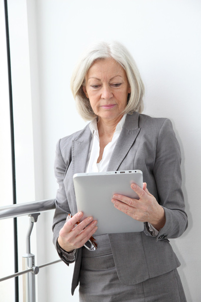 Senior businesswoman using electronic tablet in hall - Fotografie, Obrázek
