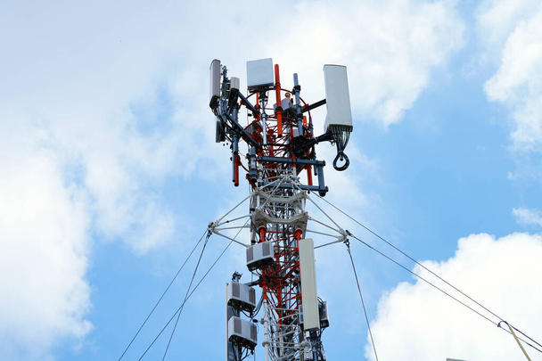 4G és 5G cellás telekommunikációs torony. Makro bázisállomás. 5G rádió hálózati távközlési berendezések rádiómodulok és intelligens antennák szerelt fémre ellen cloulds ég háttér. - Fotó, kép