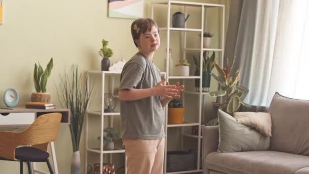 Talentvolle 14-jarige blanke meisje met down syndroom zingen lied staan in de woonkamer - Video