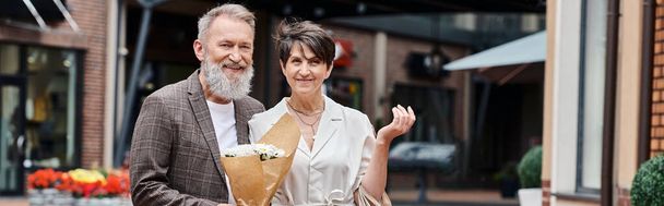 banner, boldog idős pár, csokor virág, romantika, aktív idősek, öregedő népesség, város - Fotó, kép