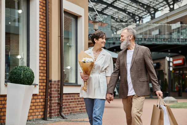 glückliches älteres Paar beim Einkaufen, Blumen, älterer Mann und Frau Händchenhalten, alternde Bevölkerung - Foto, Bild