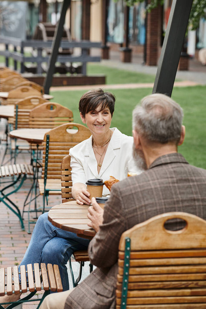 cheerful woman and man, drinking coffee in outdoor cafe, terrace, elderly couple, summer, urban - Photo, Image