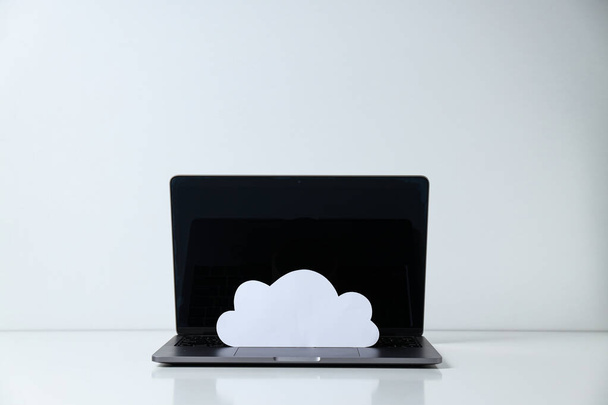 Klavyede bir kağıt bulutu olan dizüstü bilgisayar. - Fotoğraf, Görsel