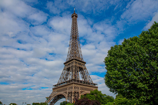 Wieża Eiffla na tle błękitnego nieba z chmurami, lato. Paryż, Francja - Zdjęcie, obraz