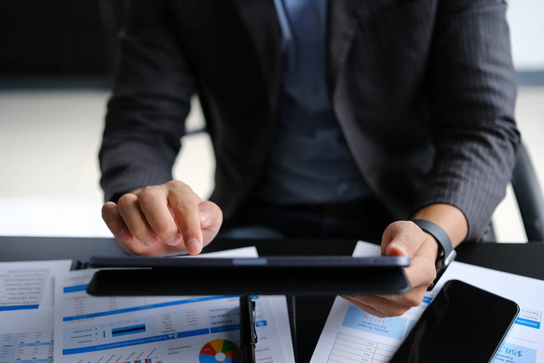 Gesneden beeld van mannelijke financier in pak met behulp van digitale tablet op kantoor bureau. Bedrijven, technologie en communicatie. - Foto, afbeelding