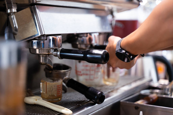 Бариста варит латте-арт кофе с помощью эспрессо-машины. - Фото, изображение