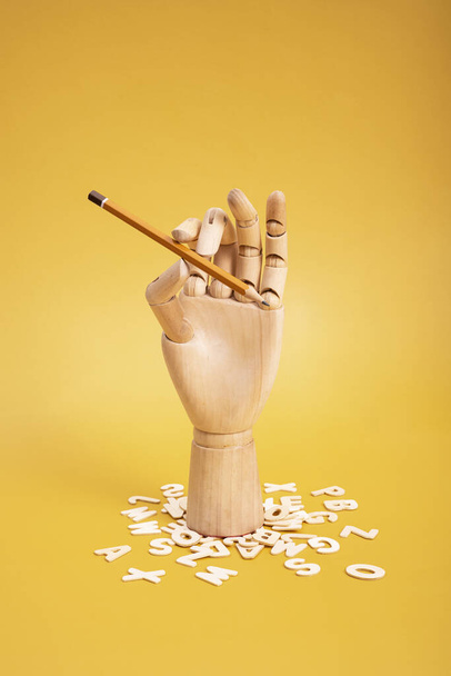 Mano de madera con lápiz y letras de madera. Foto de alta calidad - Foto, Imagen