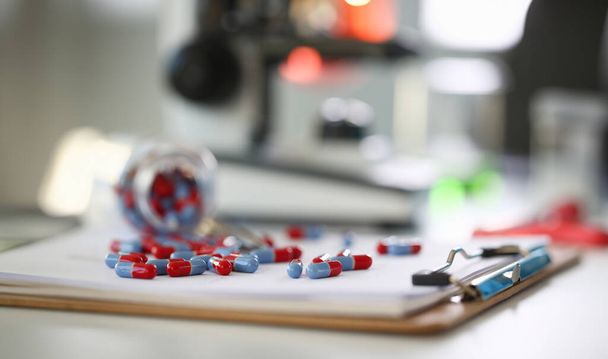 Comprimés dispersés couleur bleue et rouge sur la table de pilule de laboratoire pharmaceutique pour la prescription et le traitement de diverses maladies chimie
 - Photo, image