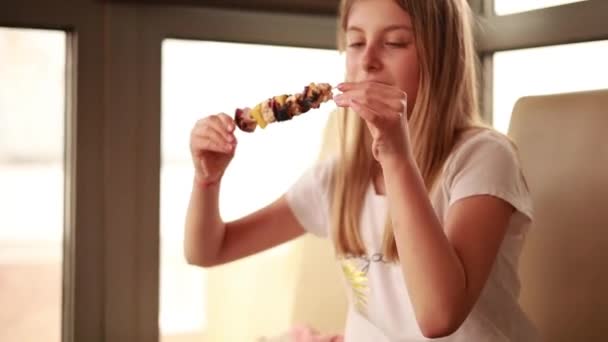 dívka jíst kuřecí špejli s ananasem doma - Záběry, video