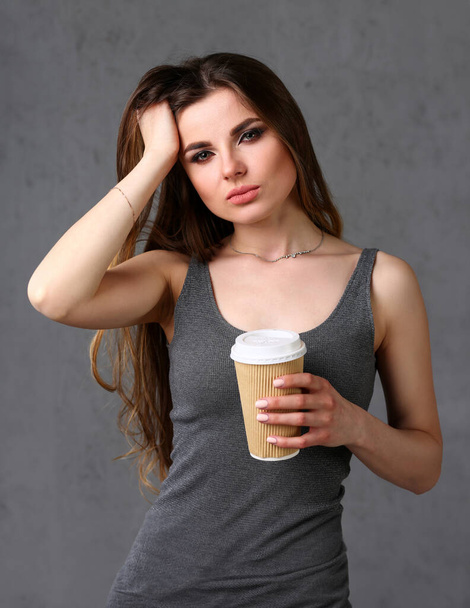 Kaunis nuori hymyilevä nainen pitää käsivarsissa valkoinen kuppi teetä muotokuva. Maukas tuoksu lämpeneminen juoma kylmänä päivänä uusi työpäivä alkaa vesi läsnä käsite
 - Valokuva, kuva