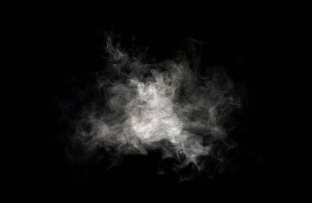 Nahaufnahme von Dampf oder abstraktem weißen Smog, der darüber aufsteigt. Wassertröpfchen, die man sieht, wie sie schön aus dem Befeuchter-Spray wirbeln. Vereinzelt auf schwarzem Hintergrund - Foto, Bild