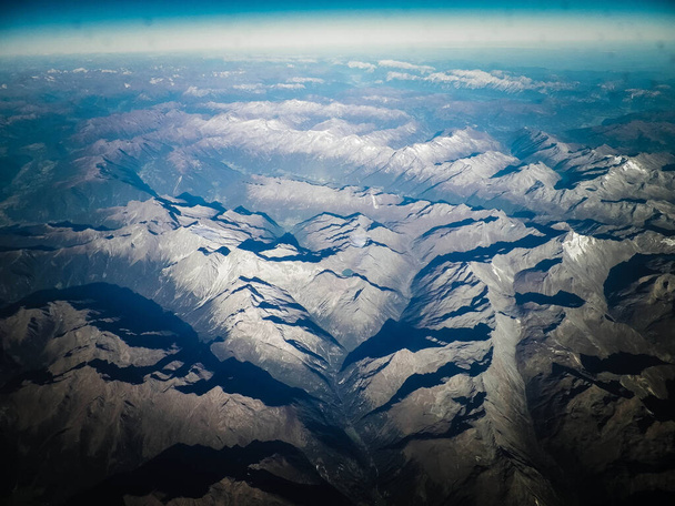 Horizon του πλανήτη Γη και Άλπεις κορυφές των βουνών. Θέα από διαστημόπλοιο ή αεροπλάνο. - Φωτογραφία, εικόνα