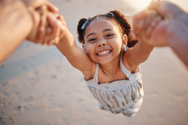 Lány gyermek, swing és pov a strandon, portré és mosoly játék, kéz a kézben vagy sebesség nyáron. Fiatal női gyerek, szülő és forog a levegőben, homok vagy boldog családi kötődés, szerelem vagy gondozás a napsütésben. - Fotó, kép