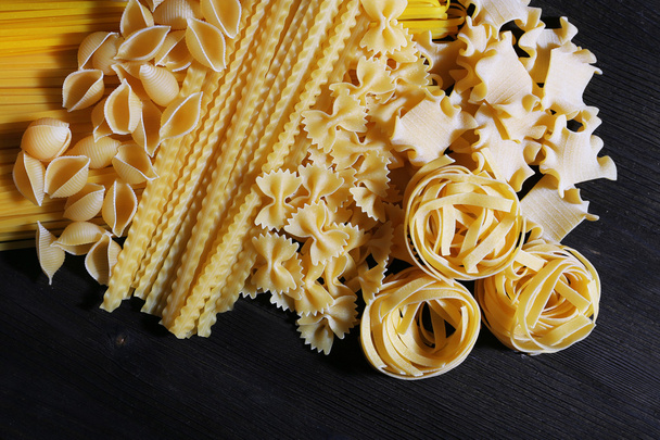 Different types of pasta on wooden table background - Photo, image
