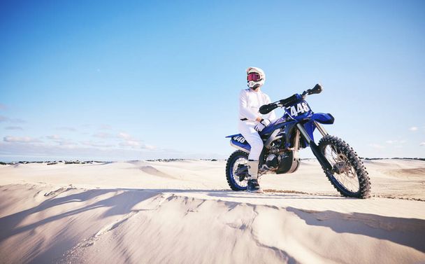 Písek, motoristické sporty a muž s motorkou pro adrenalin, dobrodružství a svobodu v poušti. Akce, extrémní výzva a muž na kole na dunách pro trénink, cvičení a závod nebo soutěž. - Fotografie, Obrázek