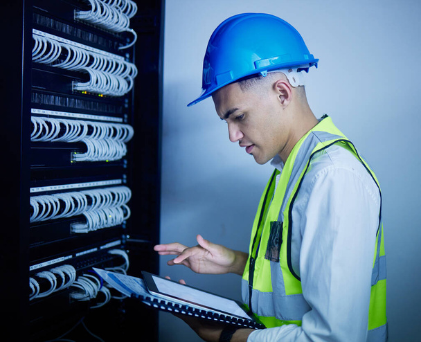 Man, engineering and tablet for data center maintenance, server room programming or inspection in IT cybersecurity. Electrician or person on typing on digital technology for coding or cables solution. - Photo, Image
