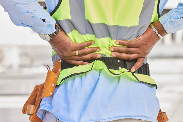Man, architect and hands in back pain, accident or posture after construction injury on site. Rear view of male person, contractor or engineer with sore spine, muscle or bruise from architecture. - Photo, Image