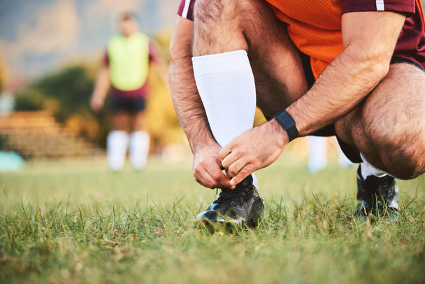Rugby, hands and athlete tie shoes to start workout, exercise or fitness. Sports, player and man tying boots in training preparation, game or competition for healthy body or wellness on field outdoor. - Photo, Image