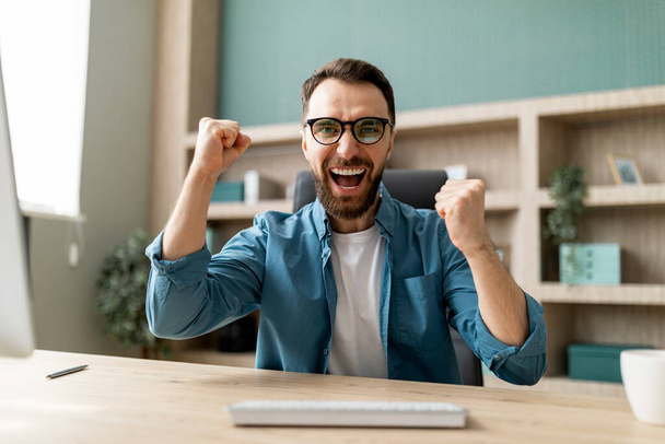Pov Shot Of Excited Young Businessman Using Computer And Celebrating Success, Cheerful Male Entrepreneur Looking At Screen And Shaking Fists, Reacting To Online Offer, Webcam Point Of View - Фото, изображение