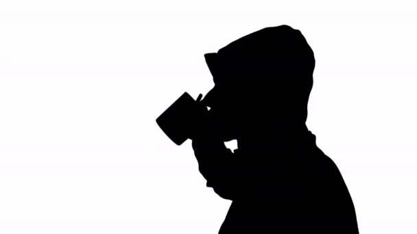 Black silhouette of a man drinking from a cup on a white background. black and white mask - Footage, Video