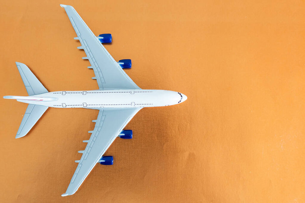 オレンジの背景、フラットレイアウト、旅行のコンセプト上の飛行機. - 写真・画像