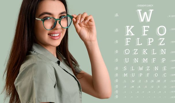 Молодая женщина в очках и с диаграммой теста глаз на цветном фоне - Фото, изображение