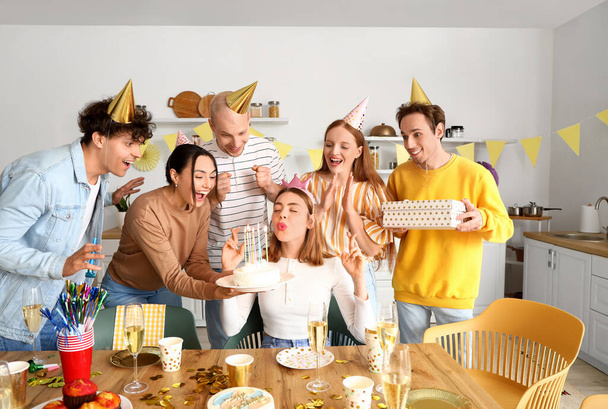 Fiatal nő kívánni a születésnapi partin a barátaival - Fotó, kép