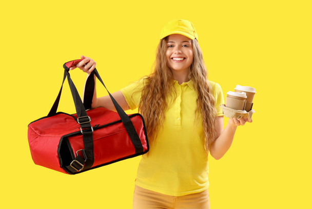 Női futár termál táska és csésze sárga háttér - Fotó, kép