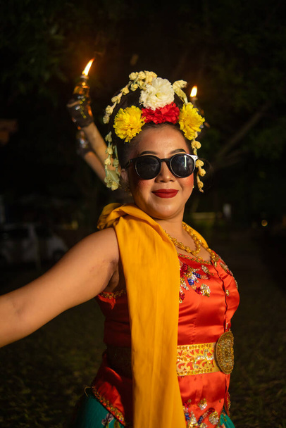 un danseur javanais traditionnel se tient debout et danse avec un corps souple tout en portant des lunettes de soleil la nuit - Photo, image