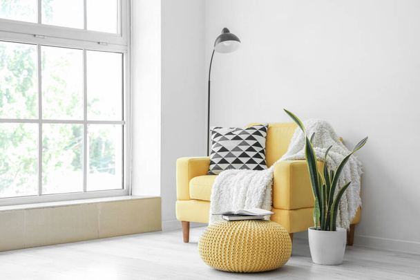 Καρέκλα κίτρινη με μαξιλάρι και καρό στο εσωτερικό του σαλονιού - Φωτογραφία, εικόνα